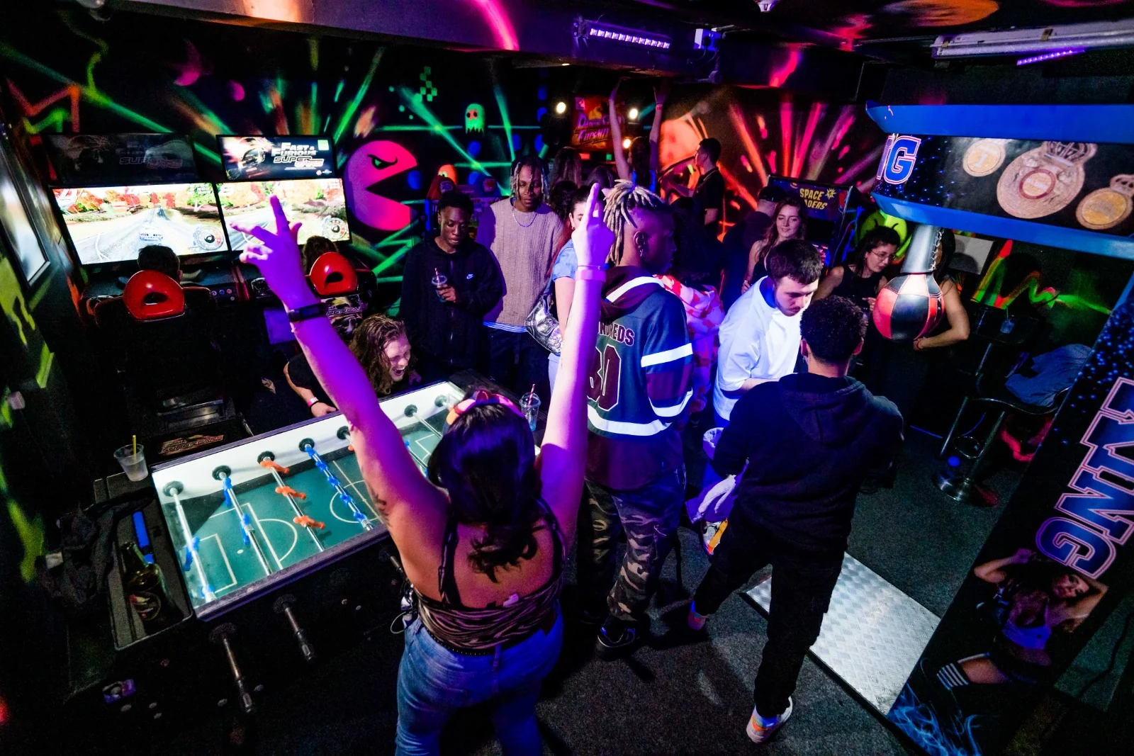 Guests dancing with their hands in the air in the DJW arcade
